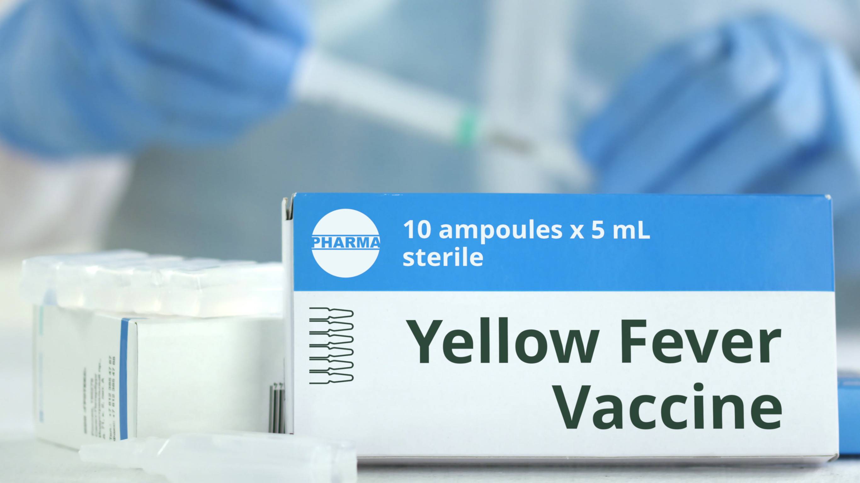 Ampoules With Yellow Fever Vaccine On The Table Near Working Laboratory Assistant