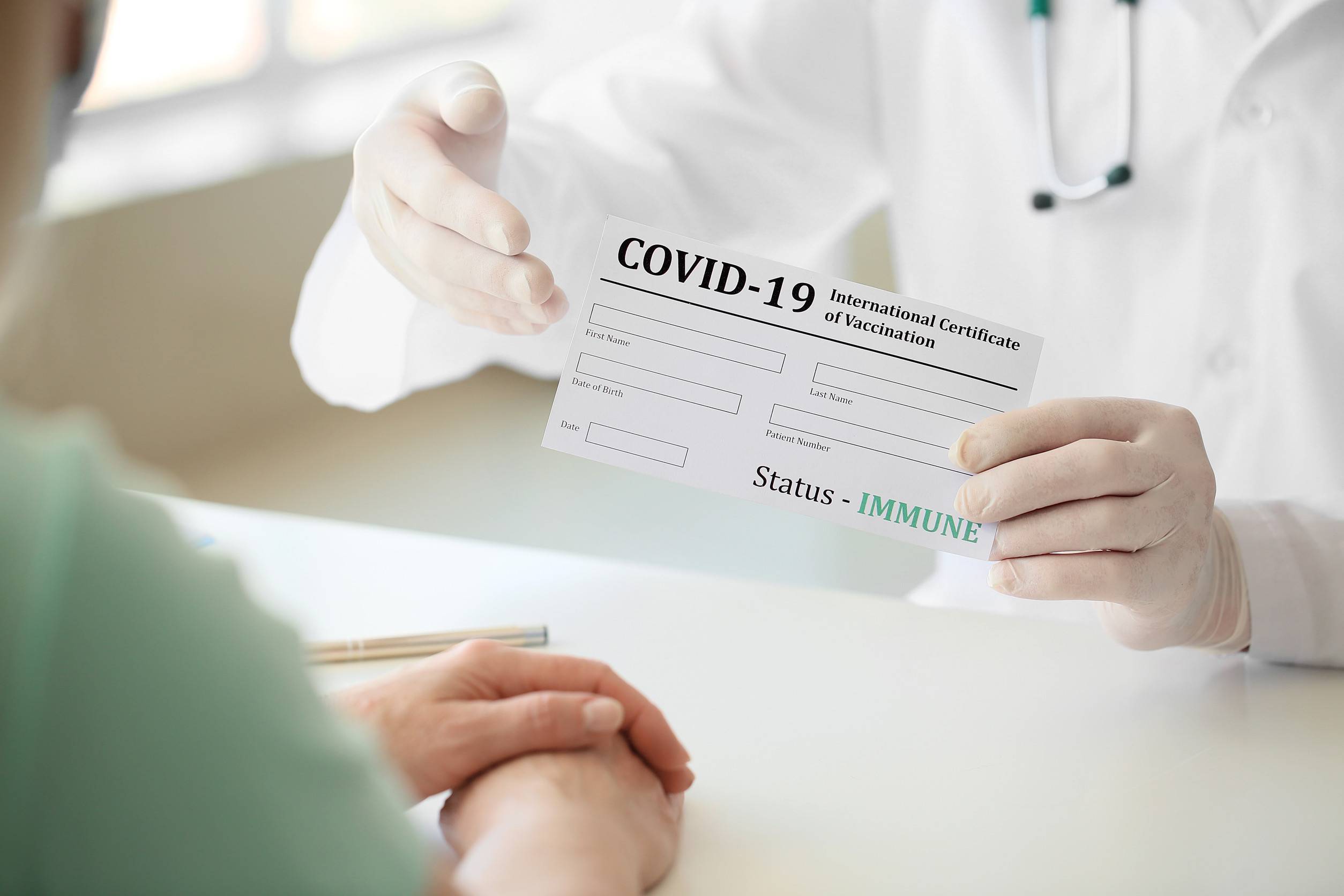 Doctor Giving Patient Her International Certificate Of Vaccination In Clinic Closeup