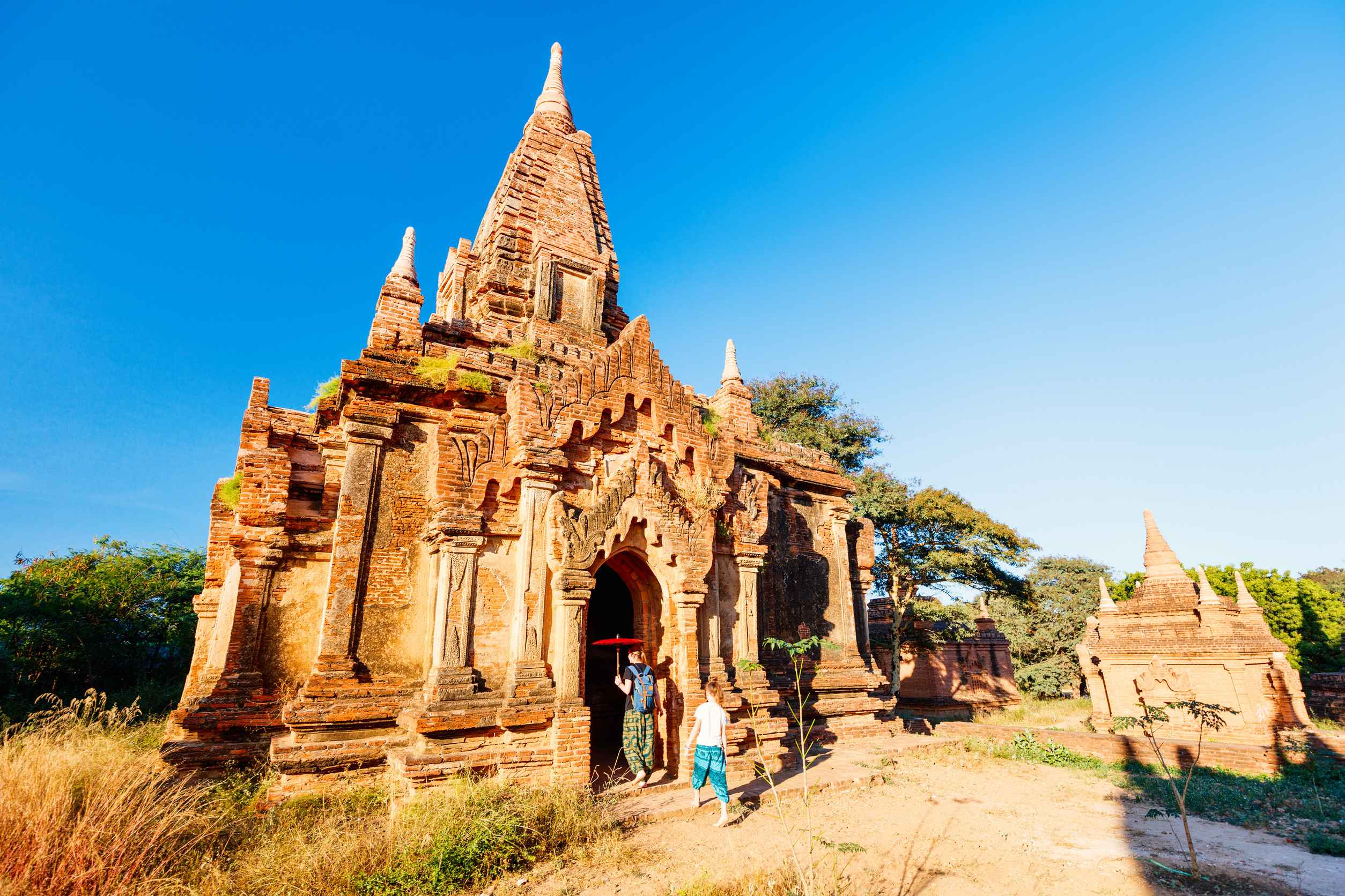 Family of mother and daughter visiting ancient temple in Bagan archeological area in Myanmar