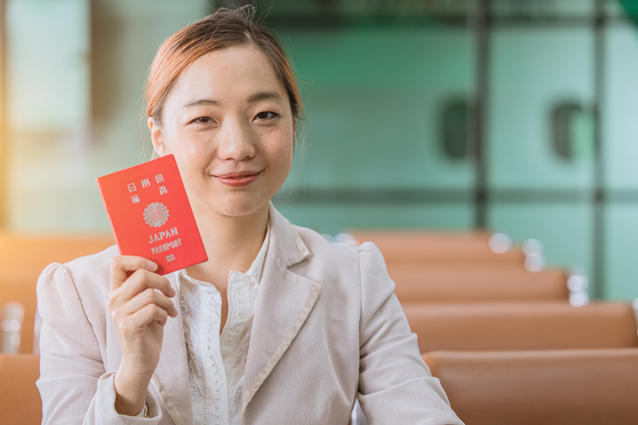 Japanese citizen woman smiling show Japan passport at airport ready to flight travel to Japan home