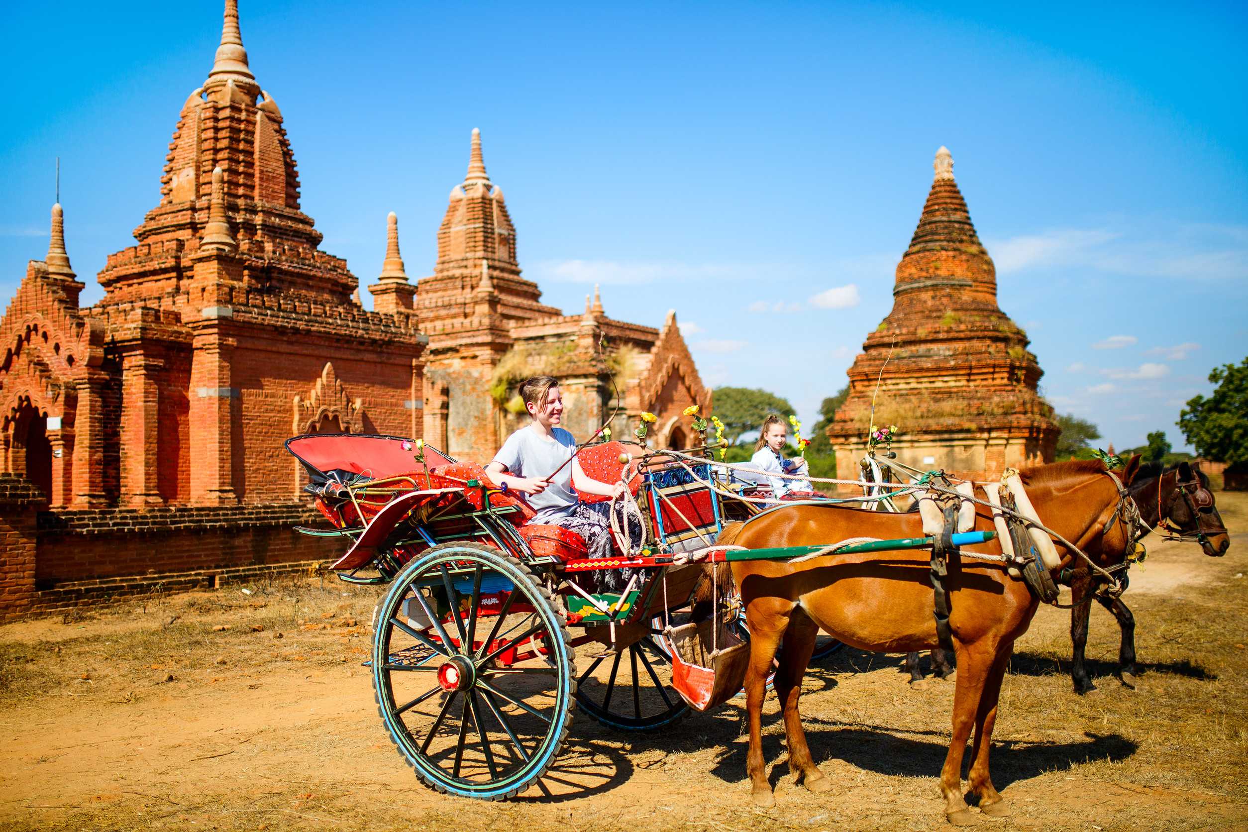 Kids brother and sister visiting ancient temples with horse cart in Bagan archeological area
