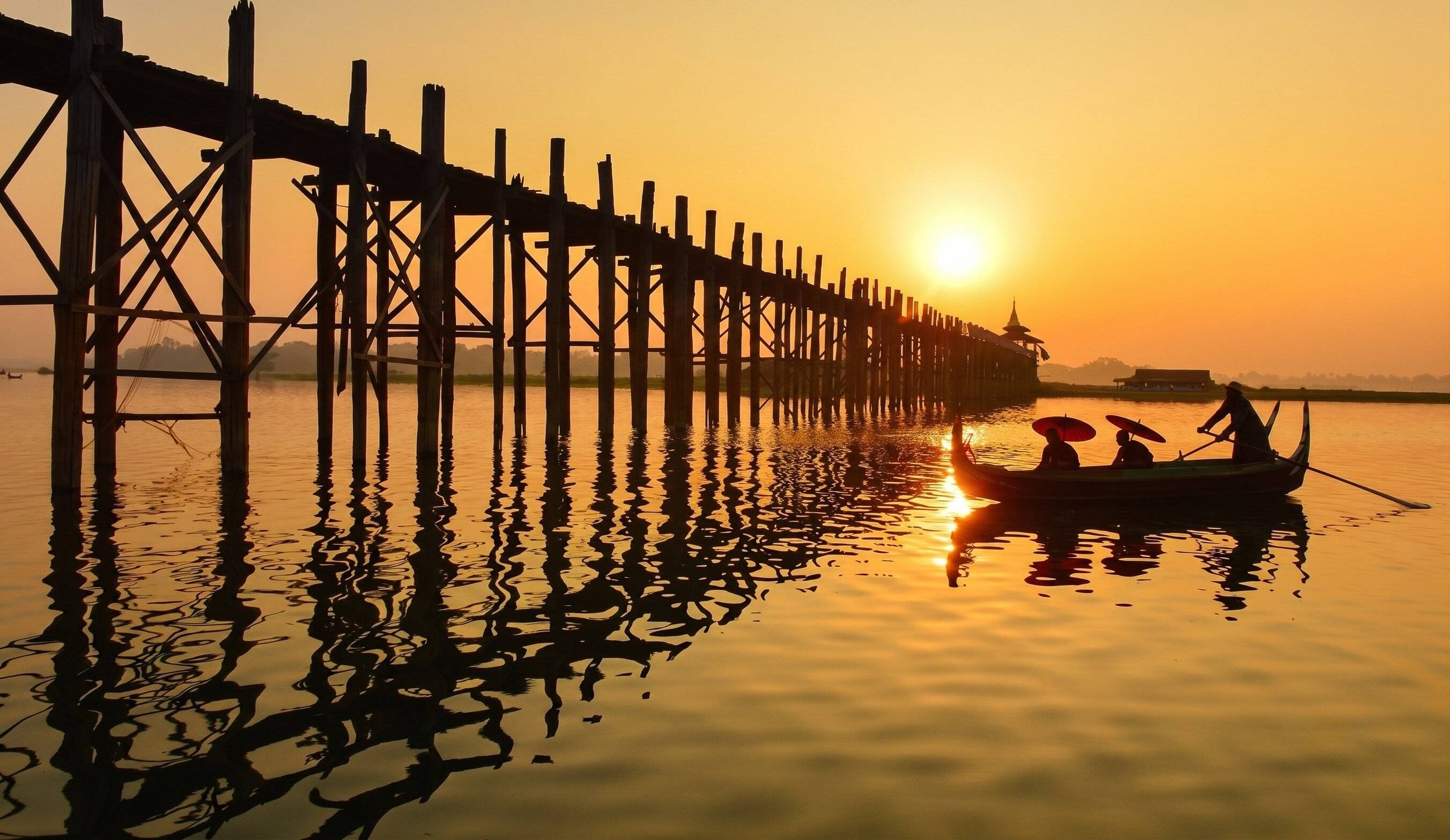 Rowboat With Passengers Next To The U Bein Bridge In Myanmar
