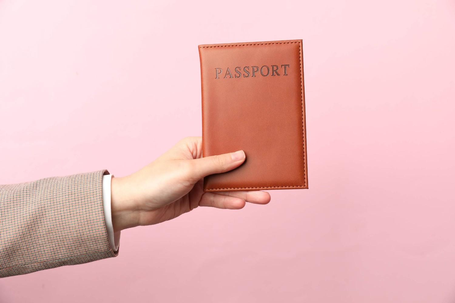 Woman Holding Passport in Bright Cover