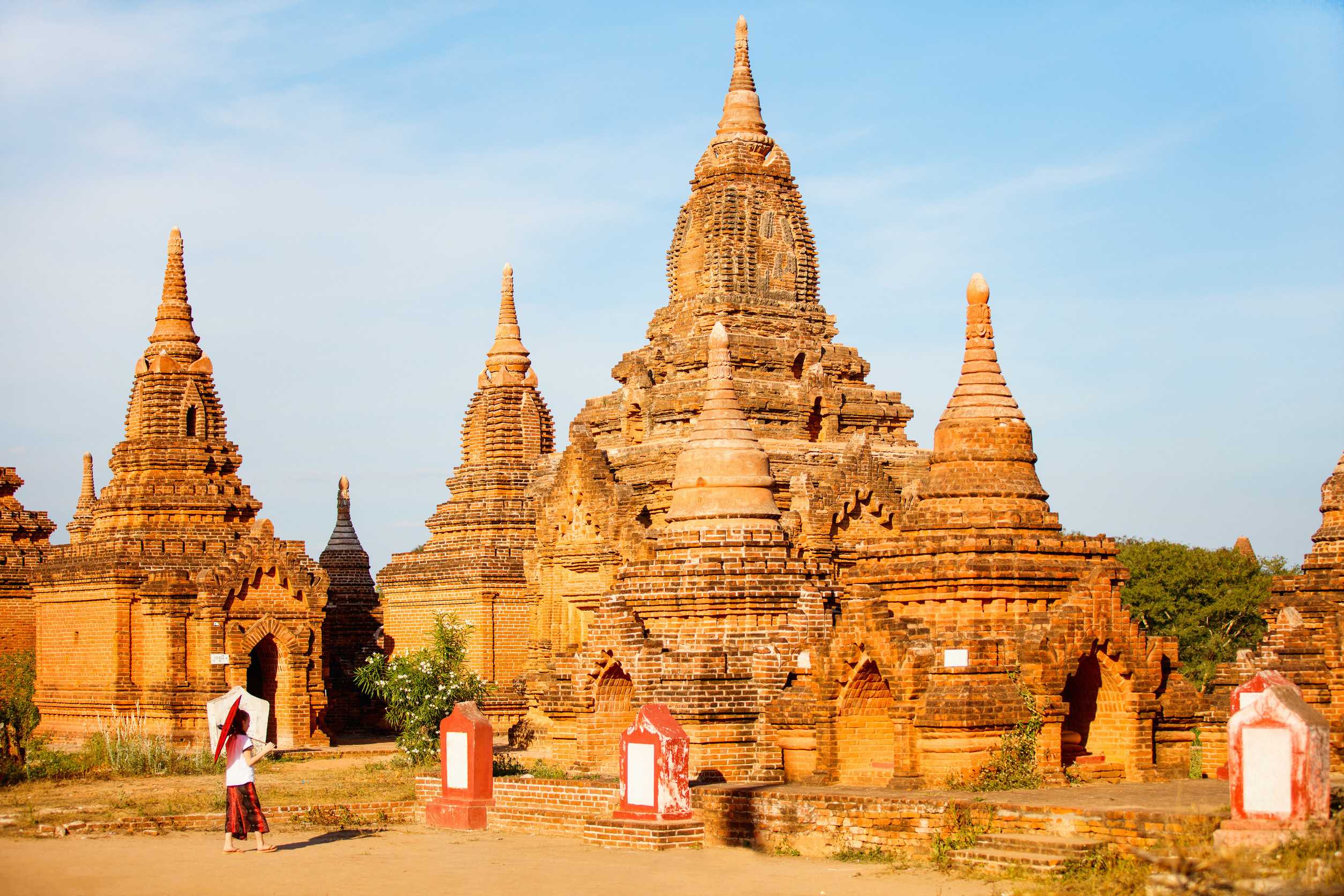 Young girl with traditional Burmese parasol visiting ancient temples in Bagan Myanmar