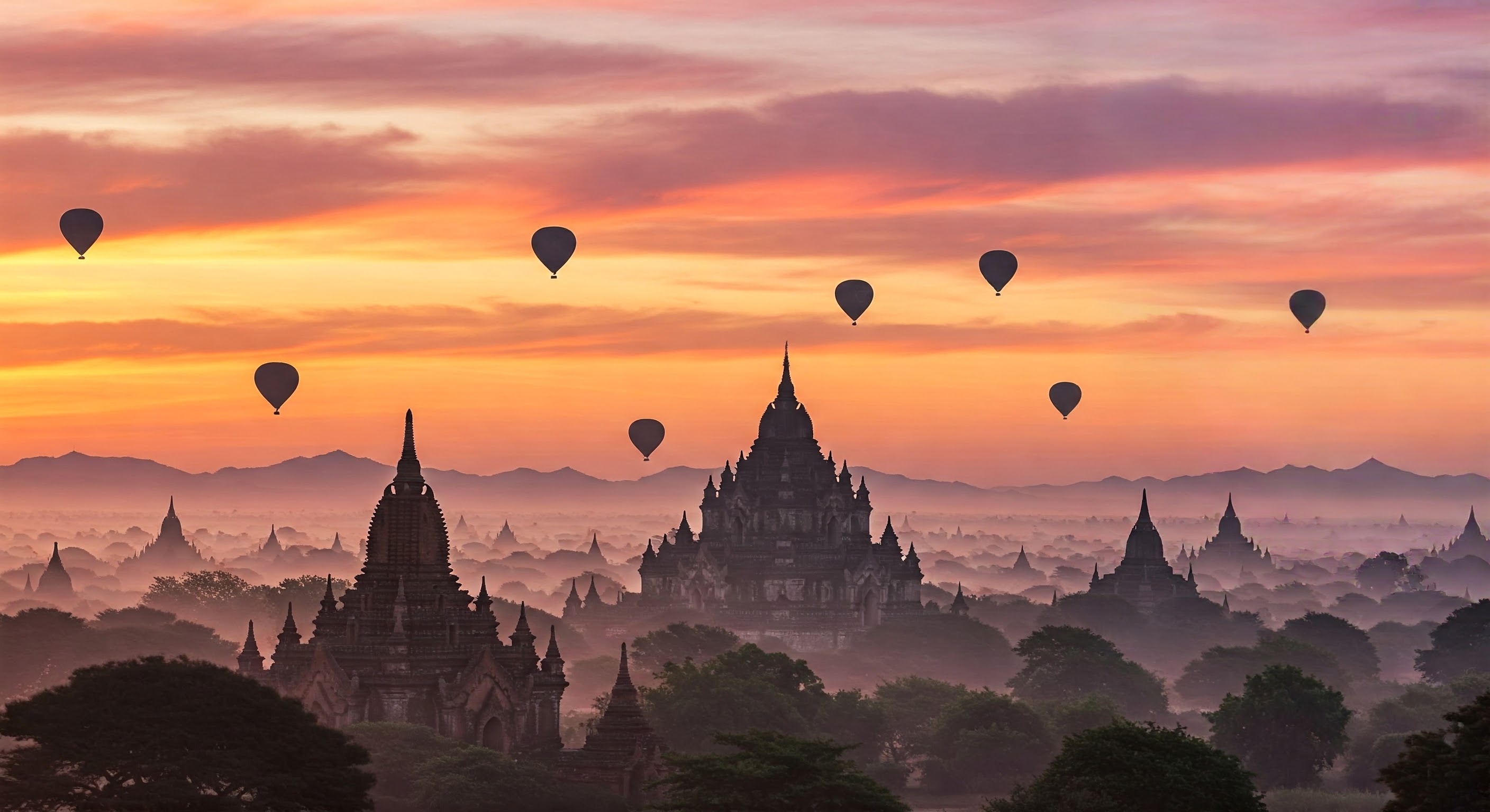 Amazing misty sunrise colors and balloons silhouettes over ancient Buddhist Temples at Bagan Kingdom. Myanmar (Burma). Travel landscapes and destinations